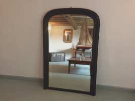 A black framed arch topped overmantle