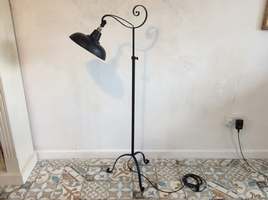 A wrought iron adjustable floor lamp